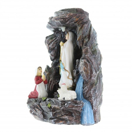 Statue of the Apparition of Lourdes in the grotto with a light
